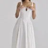 Alira Weißes Midi-Kleid aus plissierter Baumwolle mit Peekaboo-Ausschnitt Alira Weißes Midi-Kleid aus plissierter Baumwolle mit Peekaboo-Ausschnitt