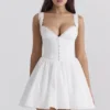 Brigitte Weißes Minikleid aus Baumwolle mit Broderie-Anglaise-Verzierung als Korsett Brigitte Weißes Minikleid aus Baumwolle mit Broderie-Anglaise-Verzierung als Korsett