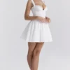 Brigitte Weißes Minikleid aus Baumwolle mit Broderie-Anglaise-Verzierung als Korsett Brigitte Weißes Minikleid aus Baumwolle mit Broderie-Anglaise-Verzierung als Korsett