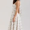 Claudia – cremefarbenes Midi-Kleid aus Stretch-Baumwolle mit Gänseblümchenprint und Neckholder-Ausschnitt Claudia – cremefarbenes Midi-Kleid aus Stretch-Baumwolle mit Gänseblümchenprint und Neckholder-Ausschnitt