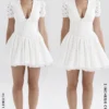 Imani Weißes Minikleid mit Plissee und Broderie Anglais Imani Weißes Minikleid mit Plissee und Broderie Anglais