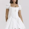 Lili Weißes Baumwoll-Minikleid mit abnehmbarem Korsett Lili Weißes Baumwoll-Minikleid mit abnehmbarem Korsett