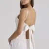 Nolia – Weißes Baumwoll-Oberteil mit Broderie-Anglaise-Verzierung und Schleifen am Rücken Nolia – Weißes Baumwoll-Oberteil mit Broderie-Anglaise-Verzierung und Schleifen am Rücken