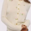 Poppie Cremefarbene Strickjacke aus Wolle und Kaschmir mit rosa Blumenstickerei Poppie Cremefarbene Strickjacke aus Wolle und Kaschmir mit rosa Blumenstickerei
